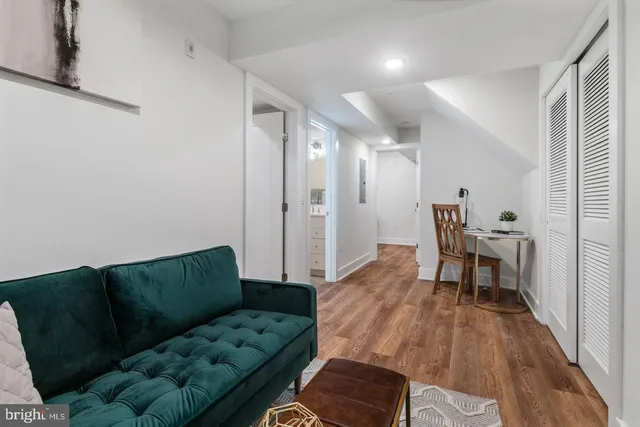 a living room with furniture and a wooden floor