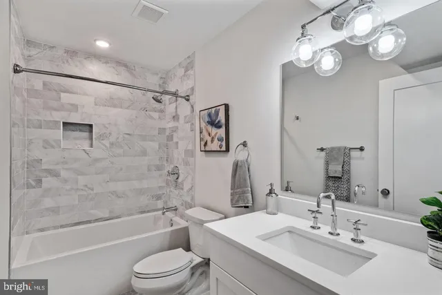 a bathroom with a toilet a sink a mirror a bathtub and shower