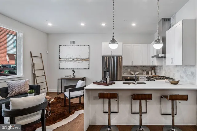 a view of kitchen with stainless steel appliances kitchen island granite countertop a table and chairs in it