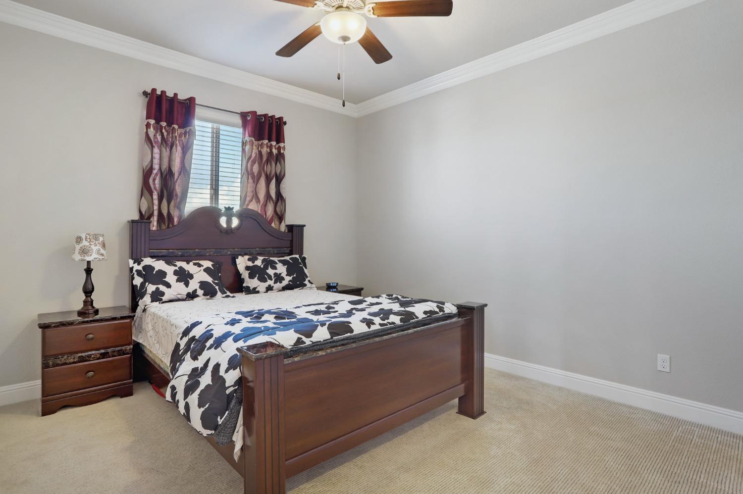2925 Fuchsia Drive Lodi, CA 95242 - Photo 18 of 44 a bed sitting in a bedroom next to a window and a chandelier
