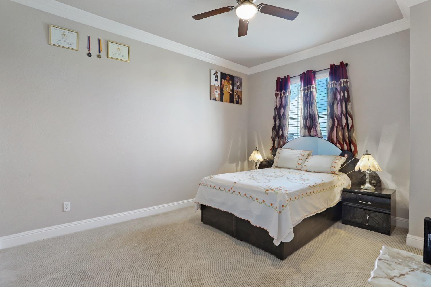 2925 Fuchsia Drive Lodi, CA 95242 - Photo 22 of 44 a bedroom with a bed lamp and a chandelier