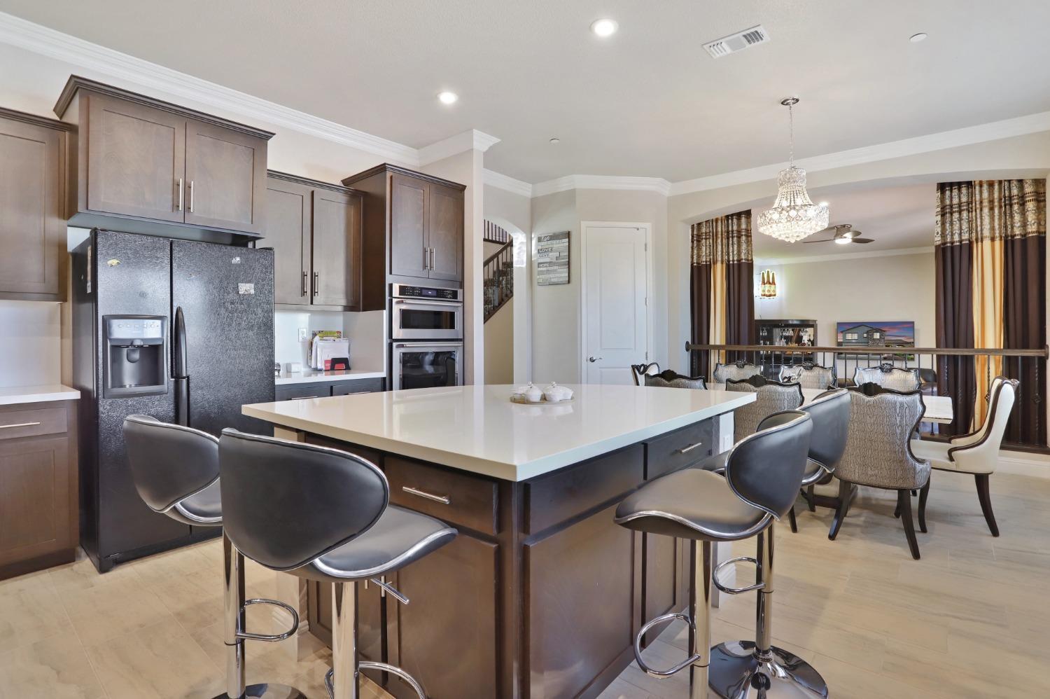 2925 Fuchsia Drive Lodi, CA 95242 - Photo 8 of 44 a kitchen with stainless steel appliances granite countertop a table chairs refrigerator and sink