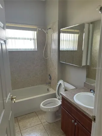 a bathroom with a granite countertop toilet a sink and bathtub