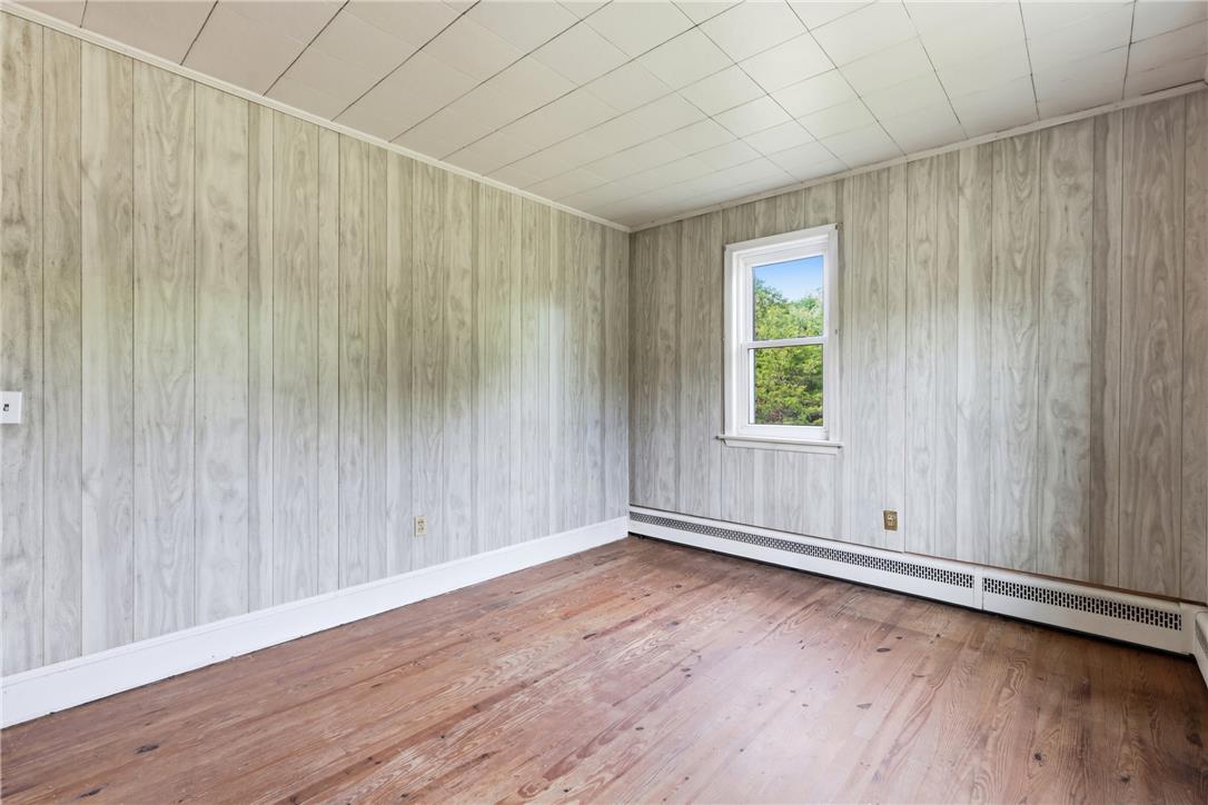 1033 Walt Road Pennsburg, PA 18073 - Photo 26 of 40 Original hardwood flooring anchors this versatile space featuring wood-look paneled walls and garden views.