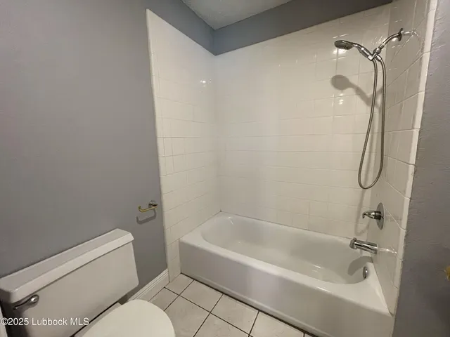 a white bath tub sitting next to a white toilet and a shower
