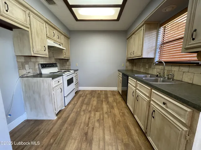 a kitchen with wooden floors wooden cabinets and stainless steel appliances