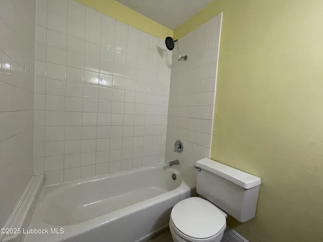 a white toilet and tub sitting next to a bathroom sink