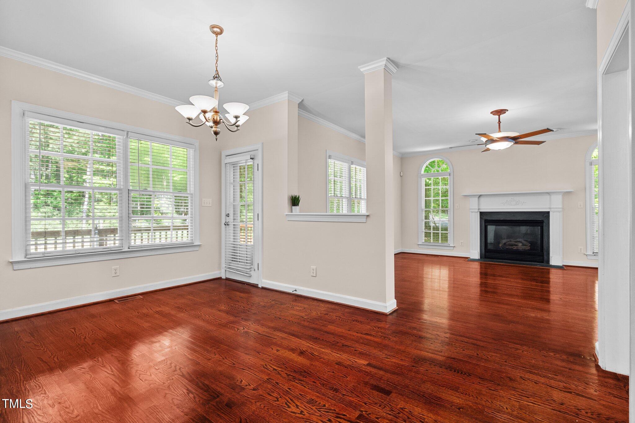 2404 Sunnystone Way Raleigh, NC 27613 - Photo 24 of 51 a view of an empty room with wooden floor fireplace and a window