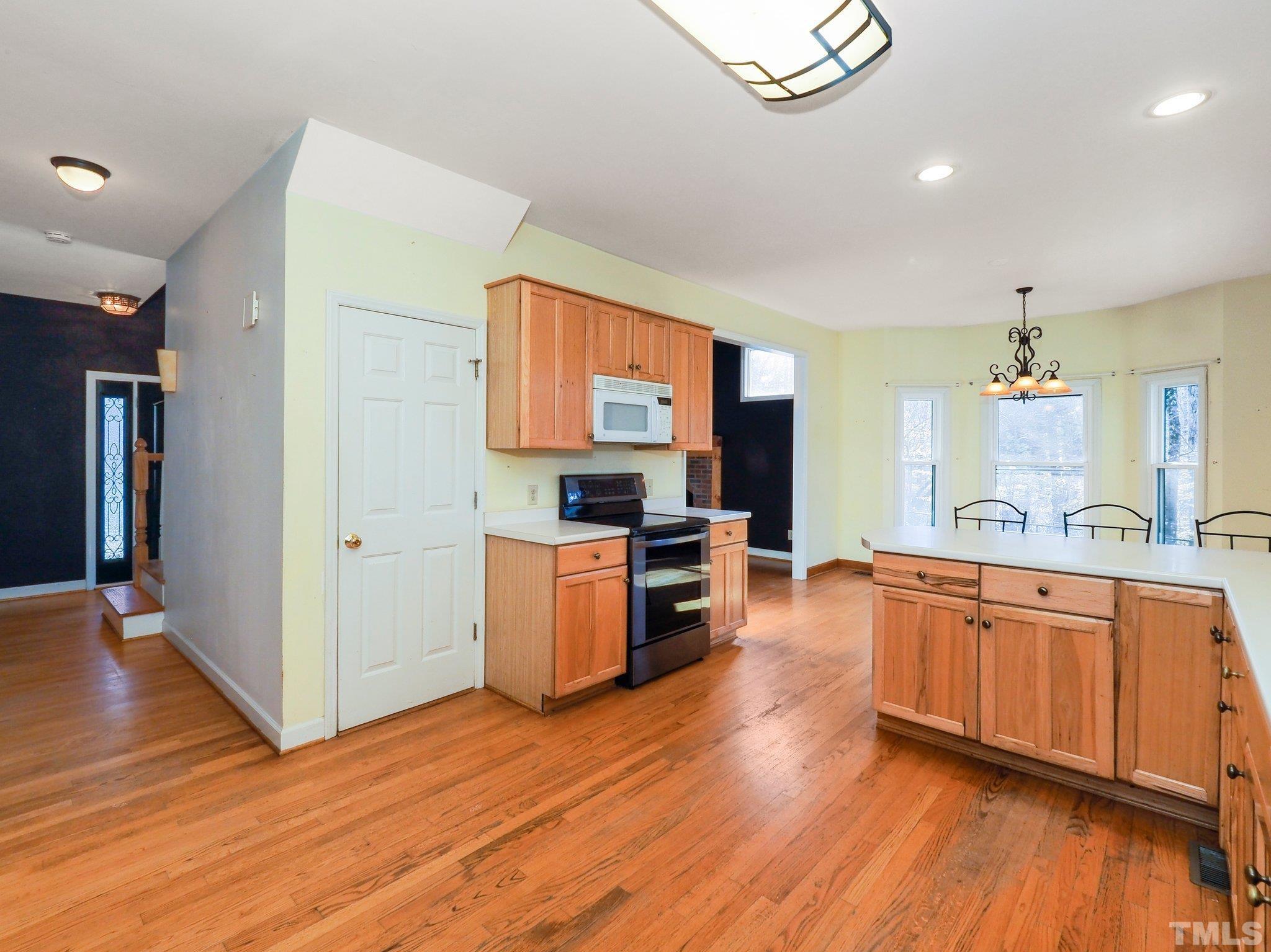 369 Potluck Farm Road Rougemont, NC 27572 - Photo 20 of 38 a large kitchen with stainless steel appliances granite countertop a large counter top and wooden floors