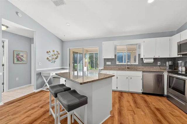 a kitchen with stainless steel appliances granite countertop a sink stove and refrigerator