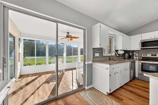 a spacious bathroom with a granite countertop sink a mirror and a bathtub