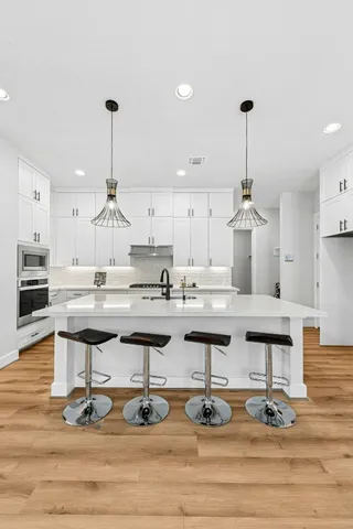 a kitchen with stainless steel appliances kitchen island granite countertop a stove and a wooden floor