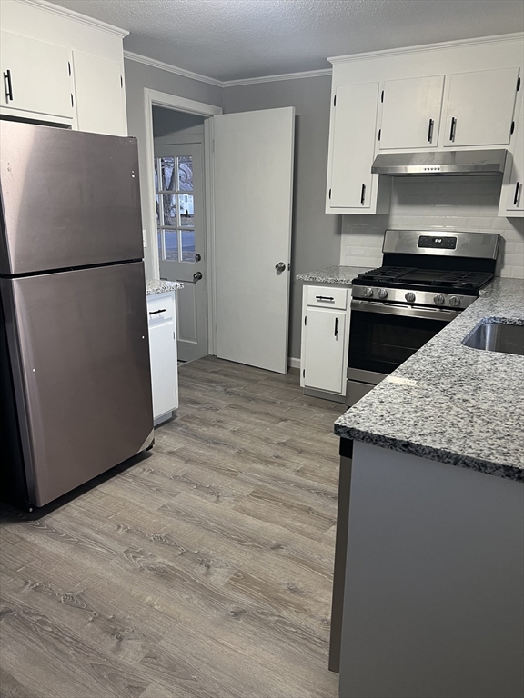 72 Clement Street Springfield, MA 01118 - Photo 14 of 36 a kitchen with a refrigerator and a stove top oven