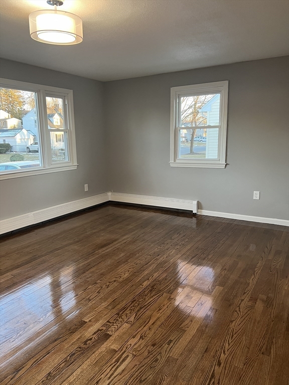 72 Clement Street Springfield, MA 01118 - Photo 19 of 36 an empty room with wooden floor and windows