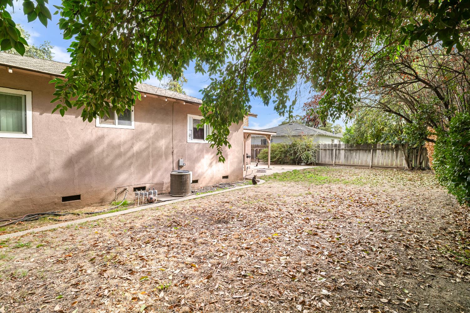 3141 Lisa Drive Modesto, CA 95350 - Photo 27 of 29 a backyard of a house with large trees and brick wall