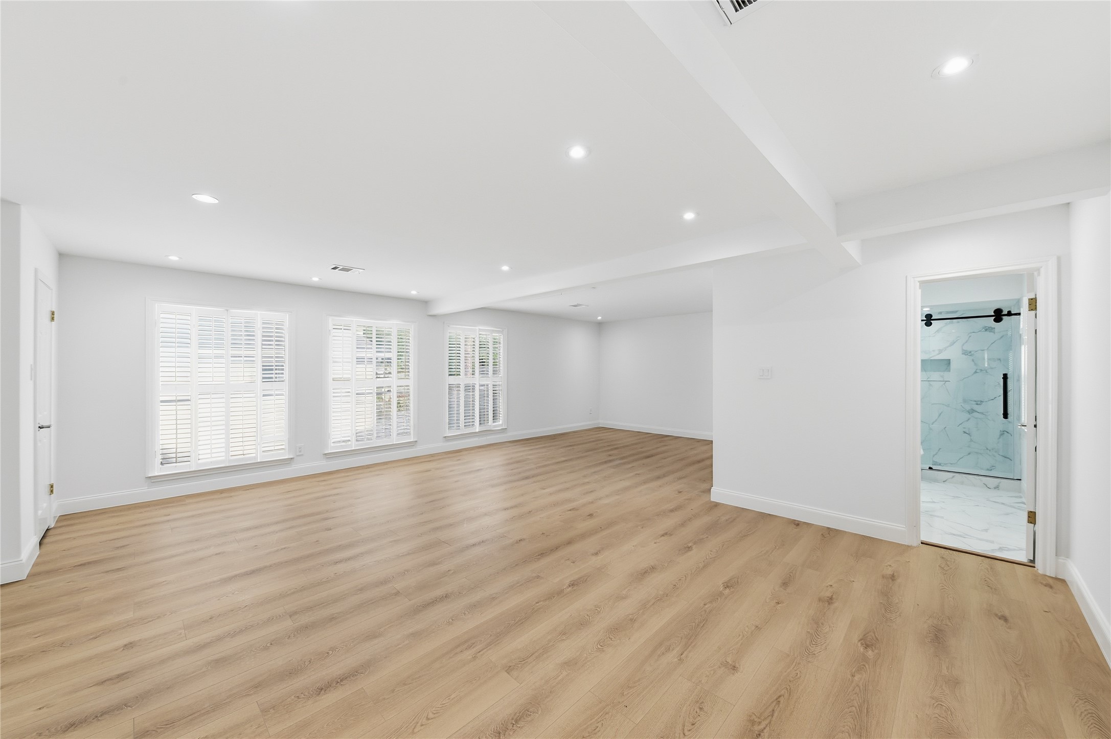 15827 Foxgate Road Houston, TX 77079 - Photo 24 of 37 Expansive upstairs game room with endless lifestyle potential - ideal for home theatre, kids' play space, fitness area, or entertainment lounge. Natural sunlight, wide-plank flooring, and a private full bathroom make it perfect for hosting or creating a custom bar or recreation zone