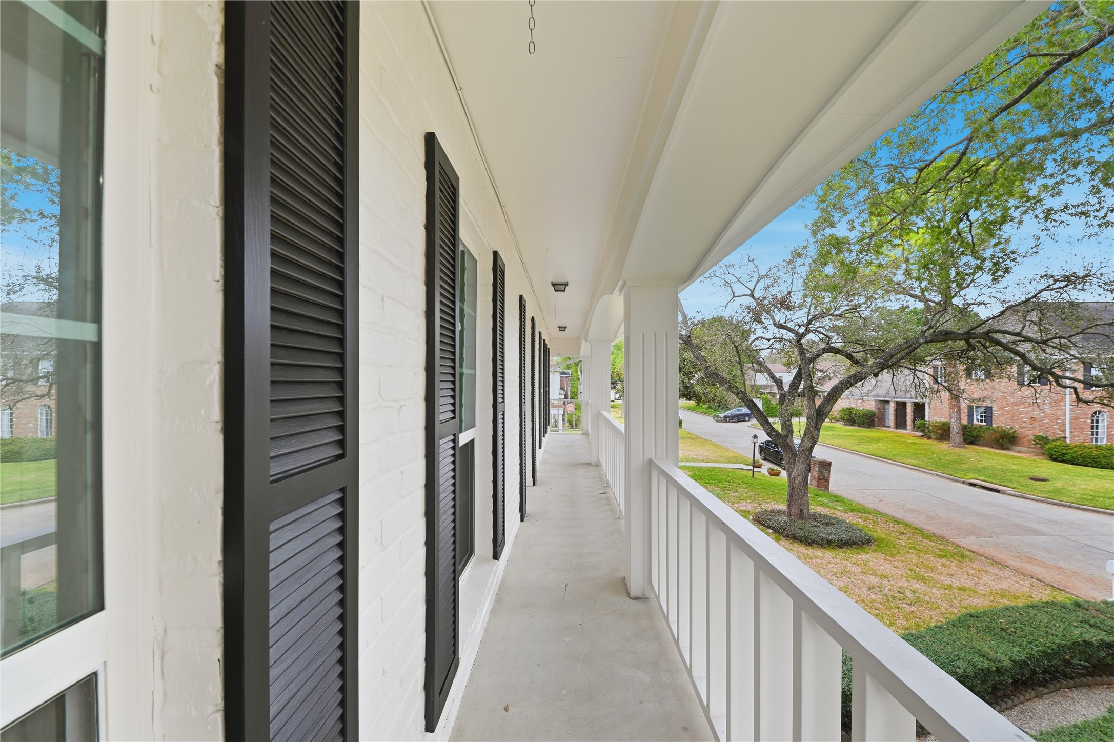 15827 Foxgate Road Houston, TX 77079 - Photo 33 of 37 Charming second-floor balcony with classic colonial railing and shutter details, overlooking the quite tree-lined street. A peaceful spot to relax and enjoy morning coffee or evening breezes