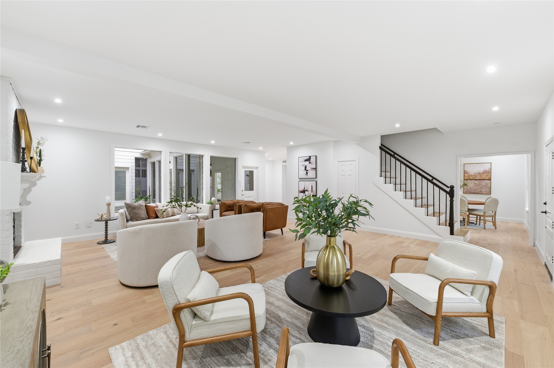 15827 Foxgate Road Houston, TX 77079 - Photo 4 of 37 Bright living room area with wide-plank wood floors, recessed lighting, and abundant natural light overlooking courtyard. Modern finishes blend seamlessly with classic architectural lines, perfect for entertaining