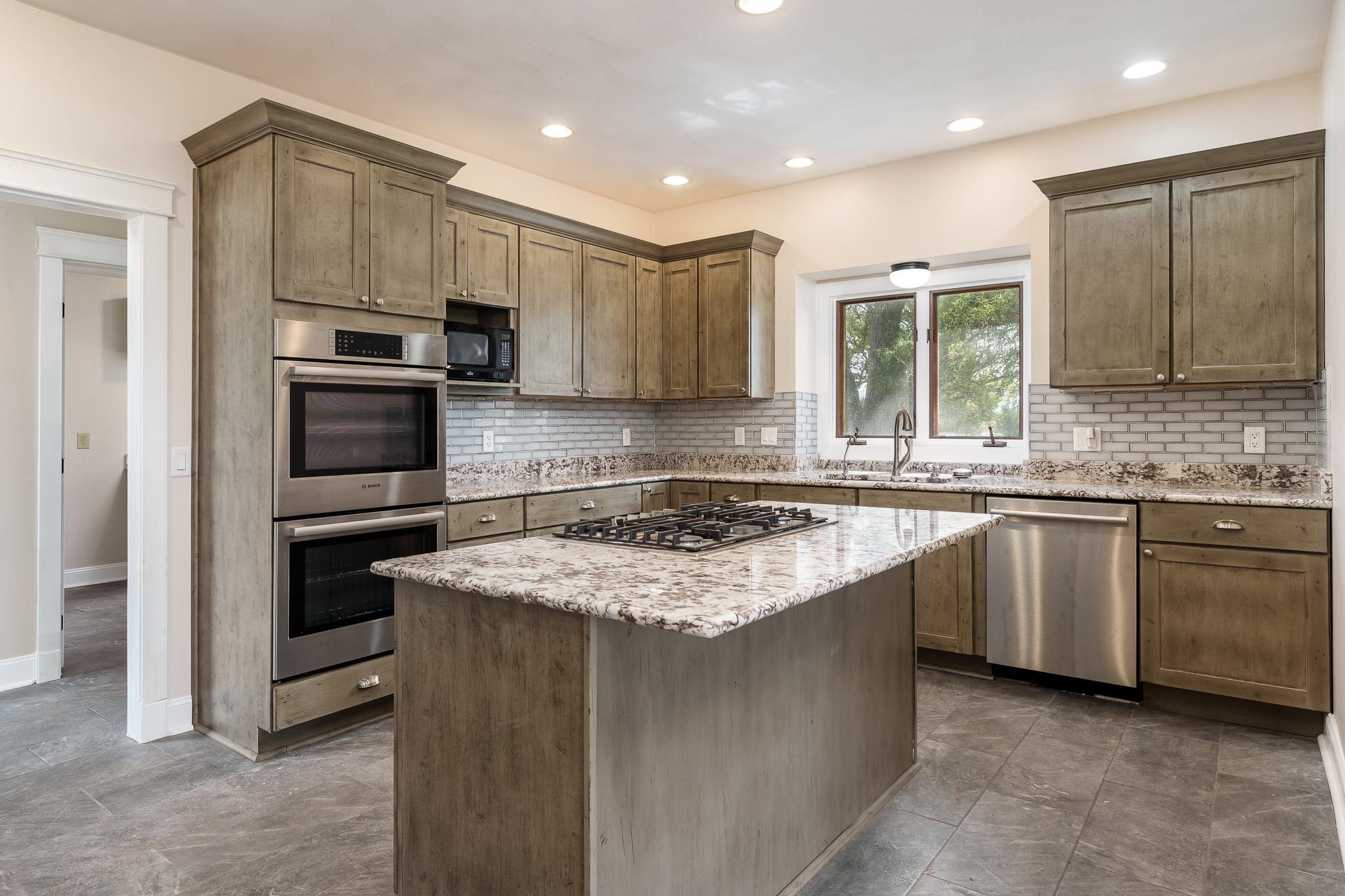 14949 Saunders Road Pecatonica, IL 61063 - Photo 23 of 88 a kitchen with kitchen island granite countertop a stove sink cabinets and refrigerator