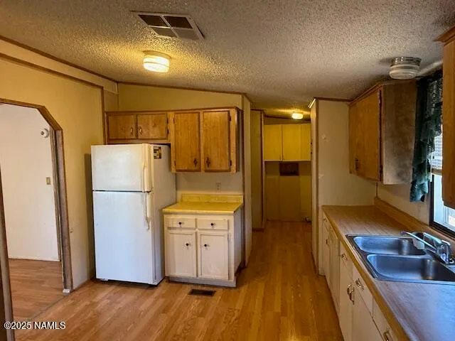 a kitchen with sink refrigerator and cabinets