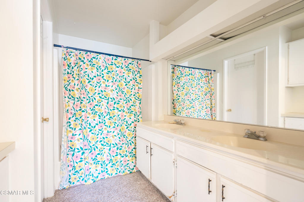 4240 Lost Hills Road, Unit 3302 Calabasas, CA 91301 - Photo 15 of 27 a bathroom with a granite countertop sink a mirror and a shower curtain