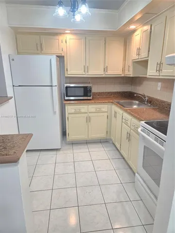 a kitchen with a white cabinets and white appliances