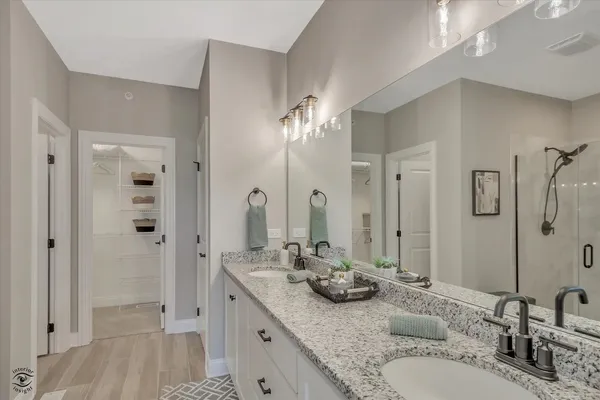 a bathroom with a granite countertop sink a mirror and shower