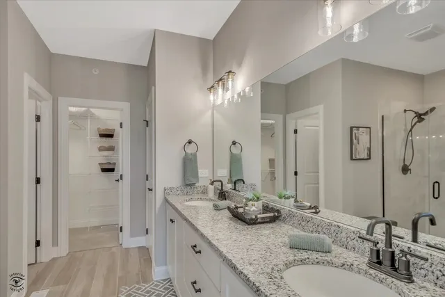 a bathroom with a granite countertop sink a mirror and shower