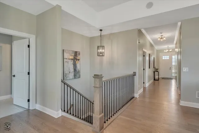 a view of a hallway with a livingroom view and windows