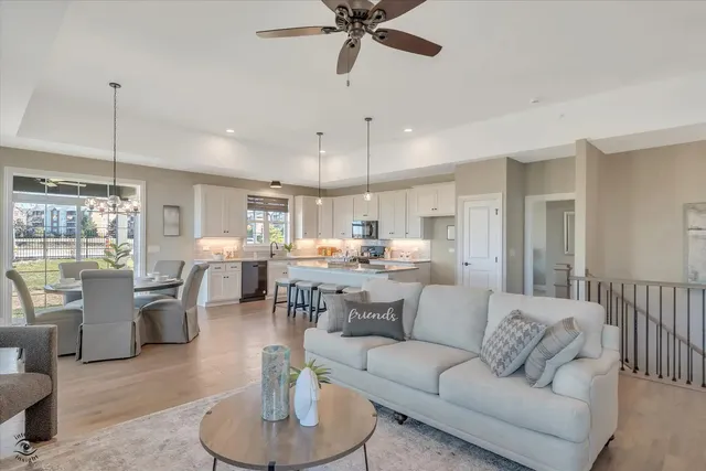 a living room with furniture kitchen view and a chandelier