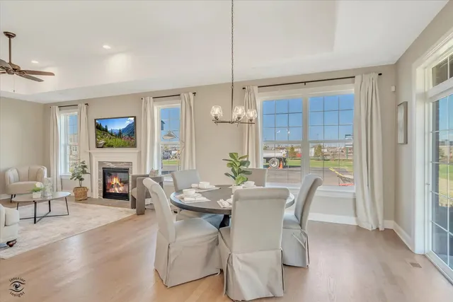 a dining room with furniture a fireplace and wooden floor