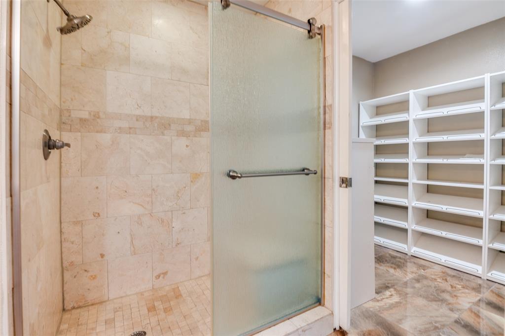 1300 Memory Lane, Unit 5214 Arlington, TX 76011 - Photo 12 of 30 Spacious walk in shower and bench in the ensuite to the primary! The pocket door can slide shut to close off the shoe shelves and chest of drawers in the extra closet!