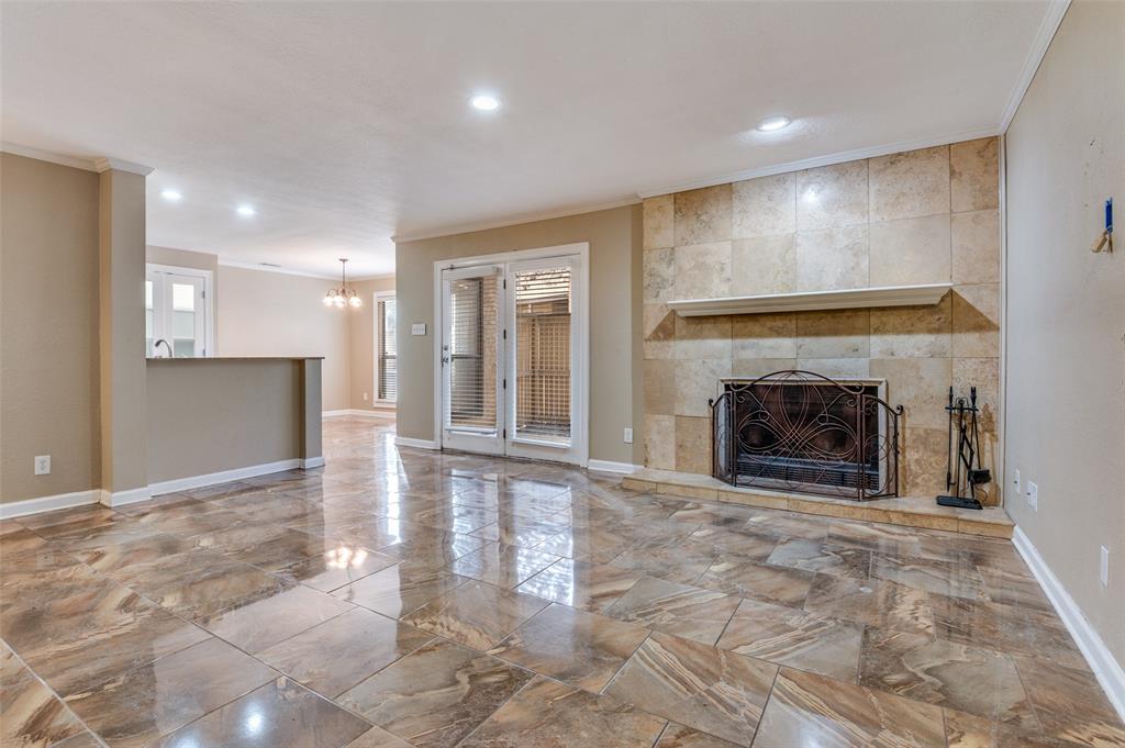 1300 Memory Lane, Unit 5214 Arlington, TX 76011 - Photo 2 of 30 Welcome to your living room with the cozy fireplace! Beautiful ceramic tile throughout the condo. Easy to entertain as the living room is open to the dining and the kitchen. The covered patio is through the door allowing easy entertaining outdoors as well! The locked storage unit is also located outside on the patio.