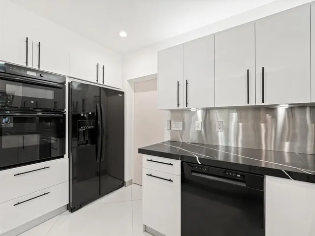 a kitchen with stainless steel appliances and white cabinets