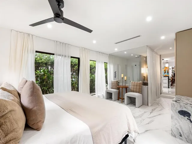 a bedroom with a large bed and ceiling fan