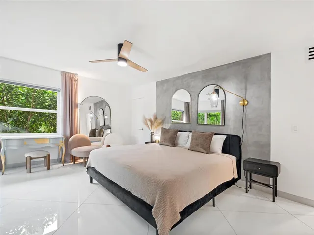 a bedroom with a bed and a large window