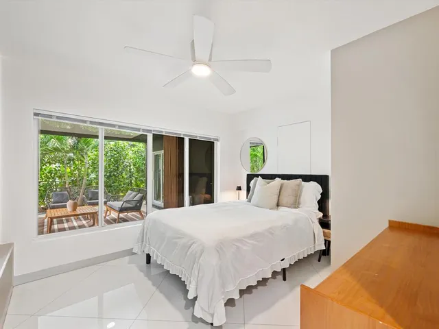 a large bed sitting in a bedroom next to a window