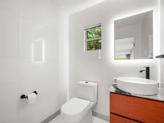 a bathroom with a sink a toilet and a mirror