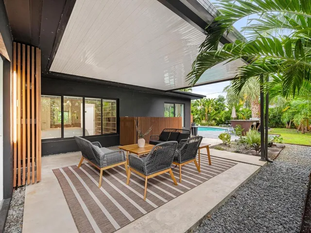 a living room with patio furniture and a floor to ceiling window