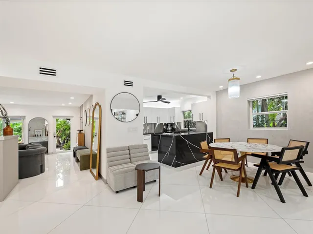 a living room with furniture a dining table and a clock