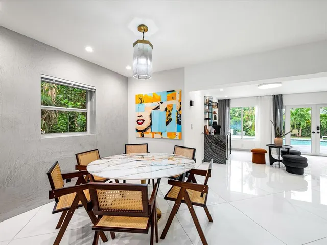 a view of a dining room with furniture a rug and a window