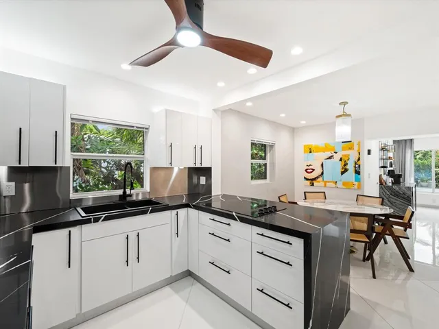 a kitchen with a sink a counter top space appliances and a window