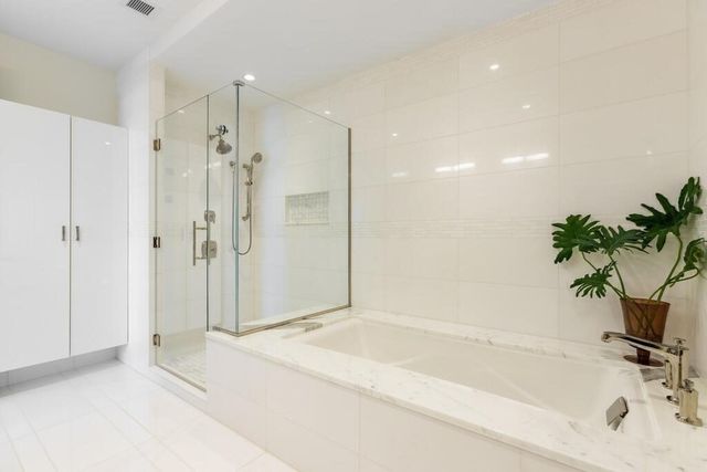a bathroom with a tub shower and sink