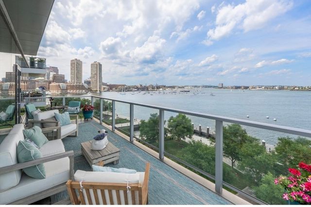 a view of a city from a balcony with outdoor seating