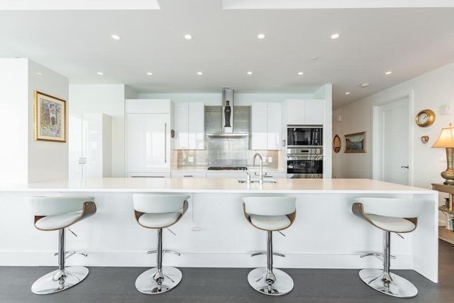 a kitchen with stainless steel appliances kitchen island granite countertop a sink and cabinets