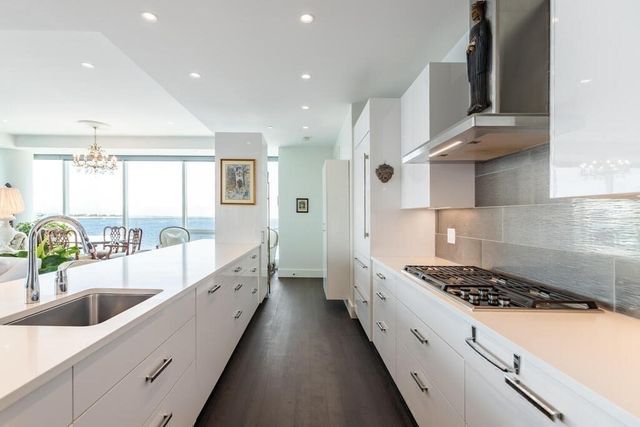 a kitchen with stainless steel appliances a sink stove and cabinets