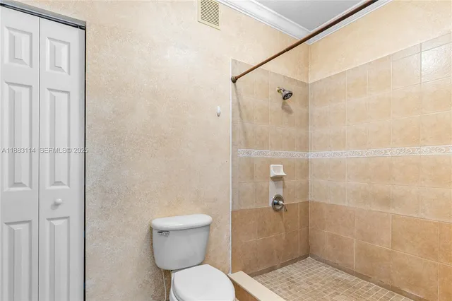 a bathroom with a toilet and a shower