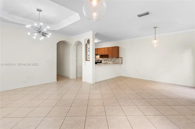 a view of a livingroom with a chandelier fan and windows