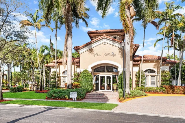 a front view of a building with a garden and plants