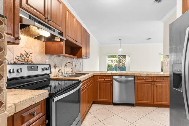 a kitchen with stainless steel appliances granite countertop a sink and a stove